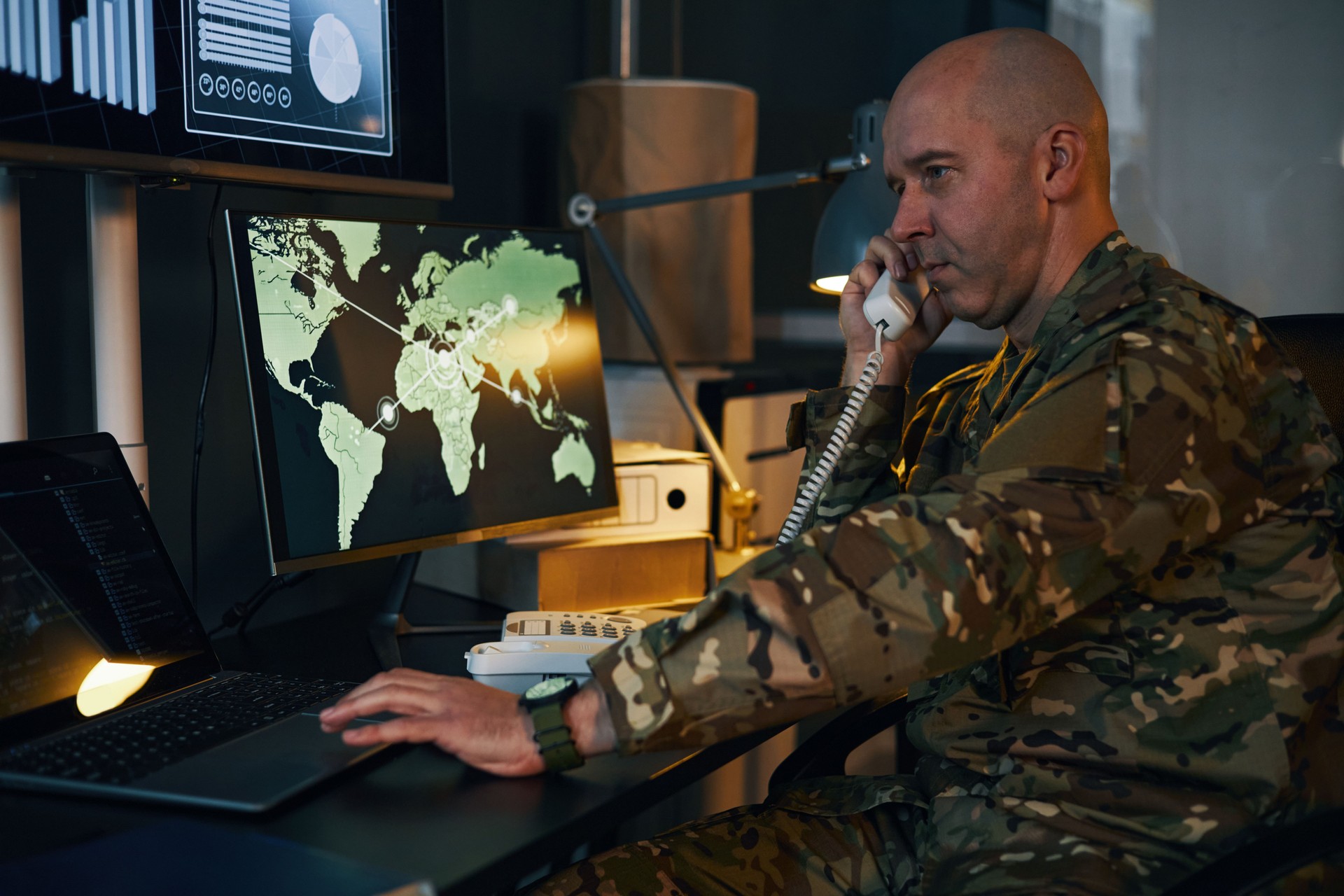 Military Officer Monitoring Global Security on Computer Screens